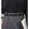A close-up of a woman wearing a black blouse, gray trousers, and a gold-toned faux leather belt.