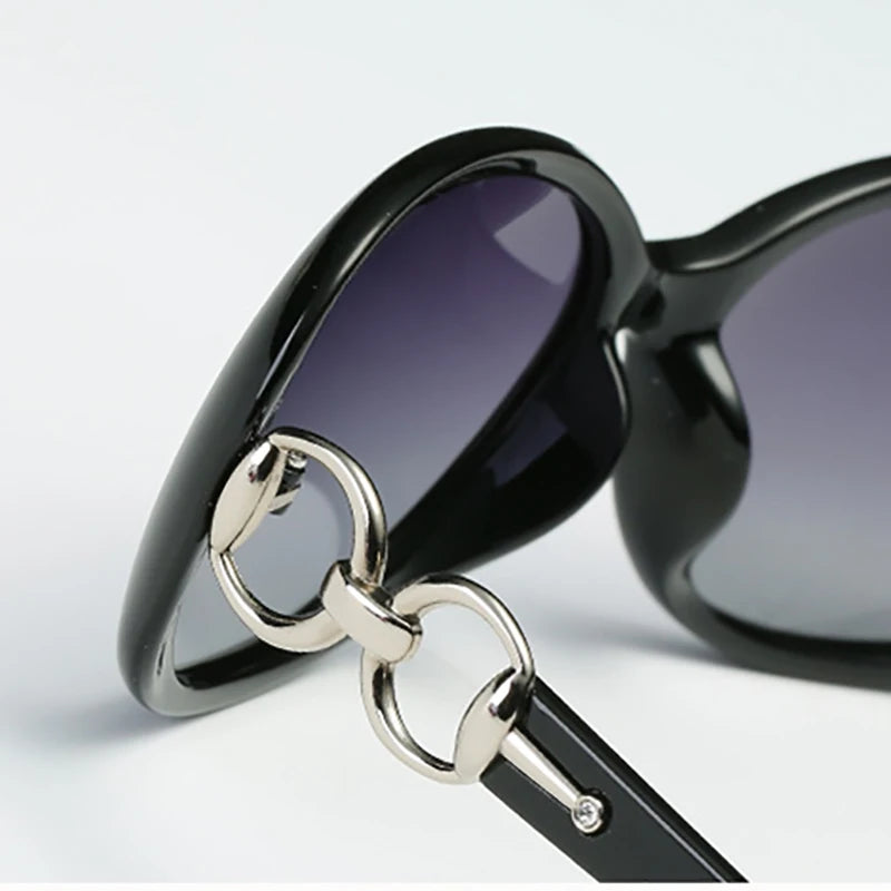 Schwarze Oversized-Sonnenbrille mit silberner Hardware in Nahaufnahme.