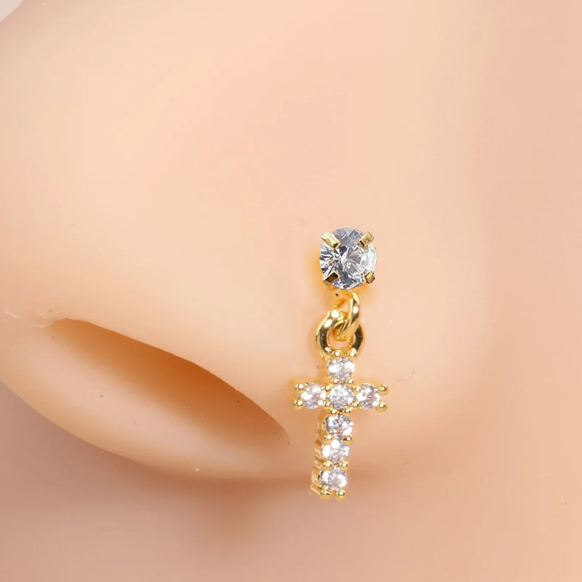 Gros plan d'un anneau nasal en acier inoxydable en forme de L, ton or, avec un pavé de diamant clair et un charm en forme de 