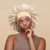 A woman wearing a satin sleep bonnet with a wrap band and a ruffled crown