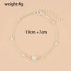 Sandale à bracelets argentés avec un charm en forme de cœur, présentée sur fond neutre.
