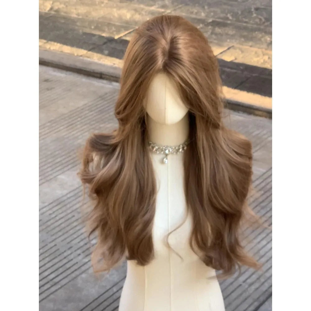 A long brown curly wave wig displayed on a mannequin against a blurred outdoor background.