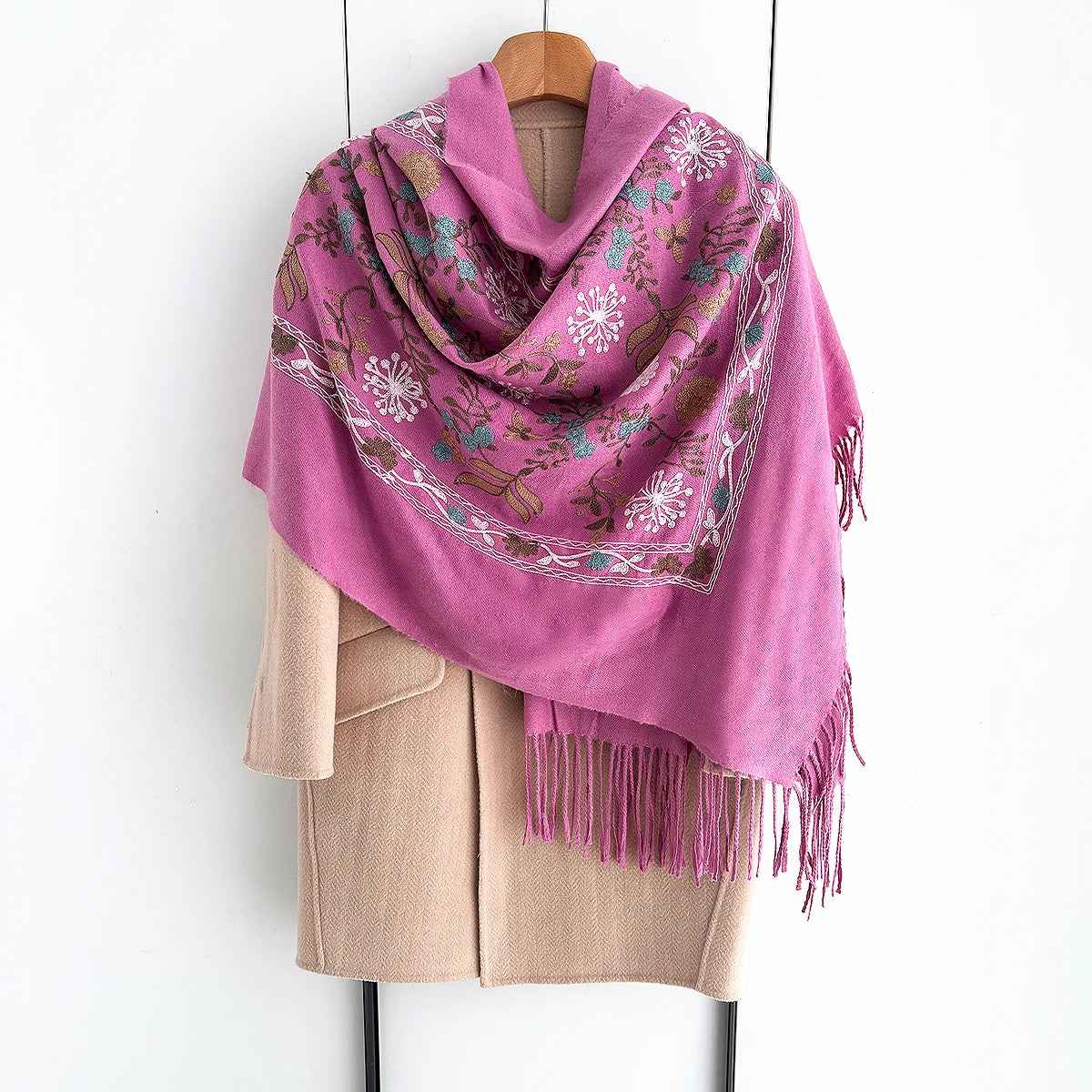 A pink luxury floral scarf draped over a beige garment.