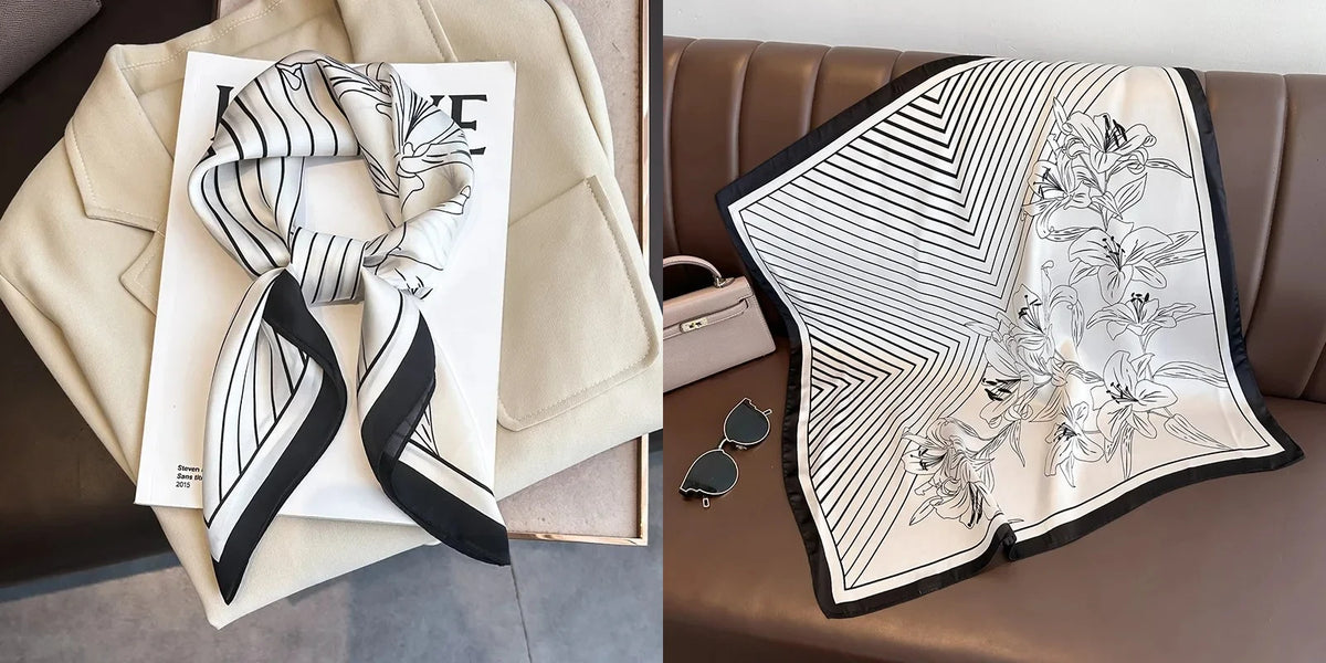 A black and white striped silk scarf with a floral print is displayed on a beige fabric and a brown leather sofa.