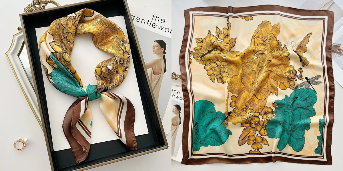 A silk scarf with a floral print featuring gold and teal leaves is displayed in a square frame.