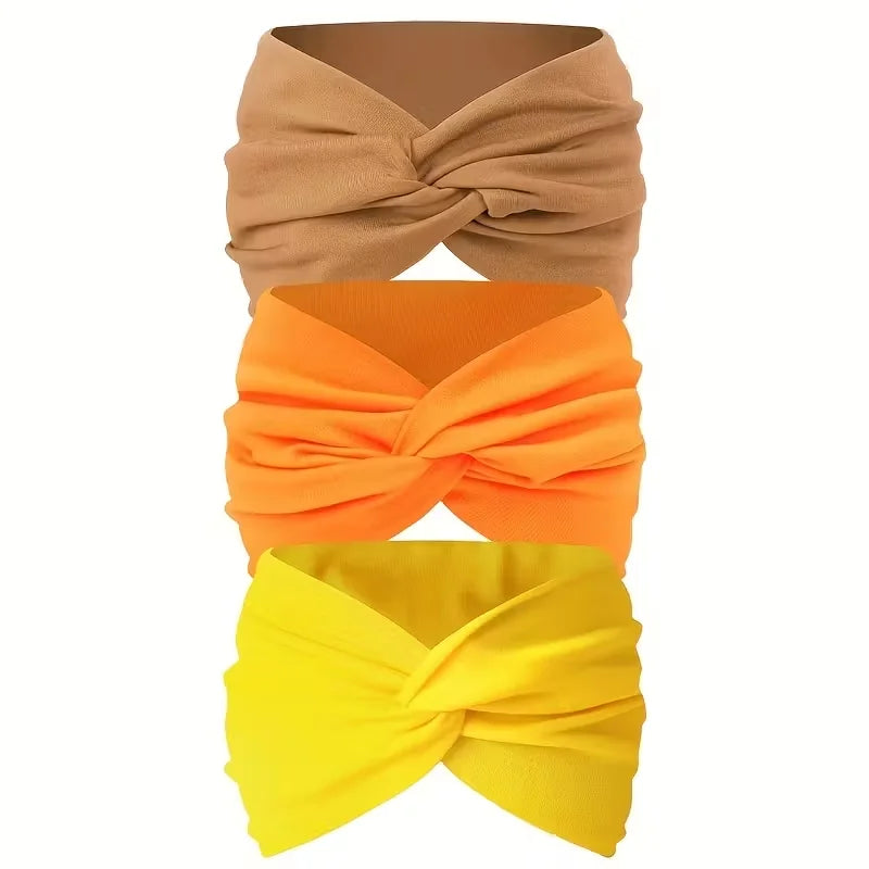 Ein Set aus drei rutschfesten, breiten Haarbänder in Beige, Orange und Gelb.
