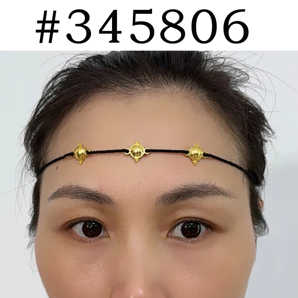 A close-up of a woman wearing a traditional Ethiopian head chain with gold accents on her forehead.