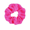 A vibrant pink satin scrunchie tied in a gathered fabric loop.