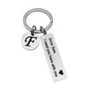 Silver keychain with a circular initial F charm and a rectangular tag that reads Drive Safe I need you here with me