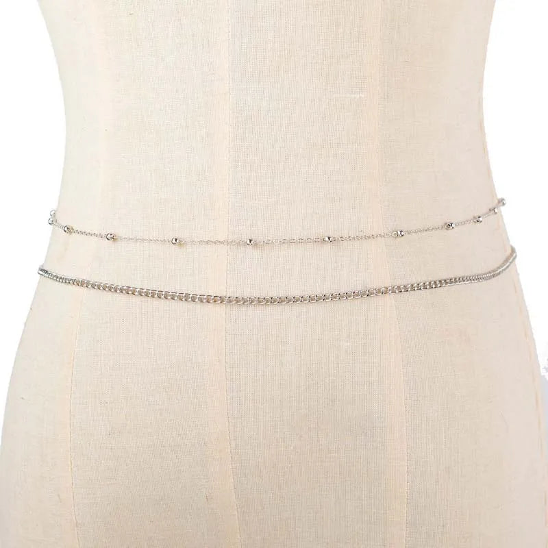 Gold layered metal belly chains displayed on a mannequin torso.