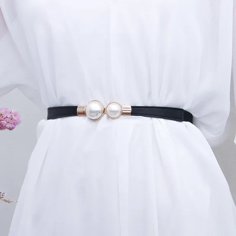 Elegenter Vintage-Perlengürtel getragen an einem weißen Kleid.