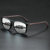 A pair of classic square sunglasses with dark frames and brown accents resting on a dark surface.