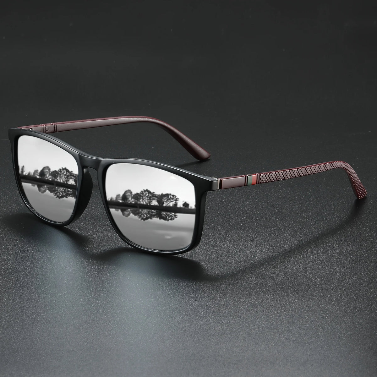 A pair of classic square sunglasses with dark frames and brown accents resting on a dark surface.