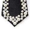 A black necktie decorated with a pearl and rhinestone pattern.
