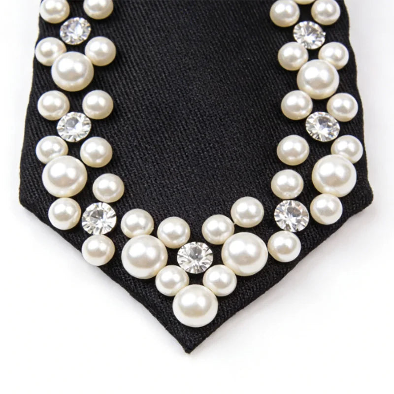 A black necktie decorated with a pearl and rhinestone pattern.