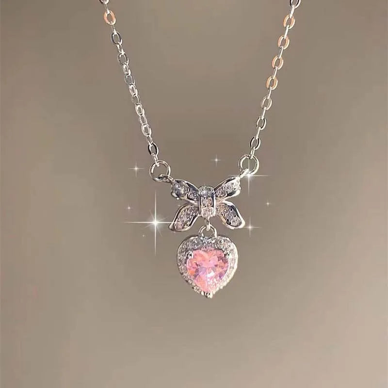 A delicate silver necklace featuring a sparkling pink heart-shaped zircon pendant.