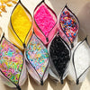 A collection of colorful disposable rubber hair ties in various shades including yellow, pink, and black.