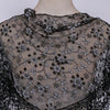 Black sheer floral lace scarf draped over a mannequin neck.