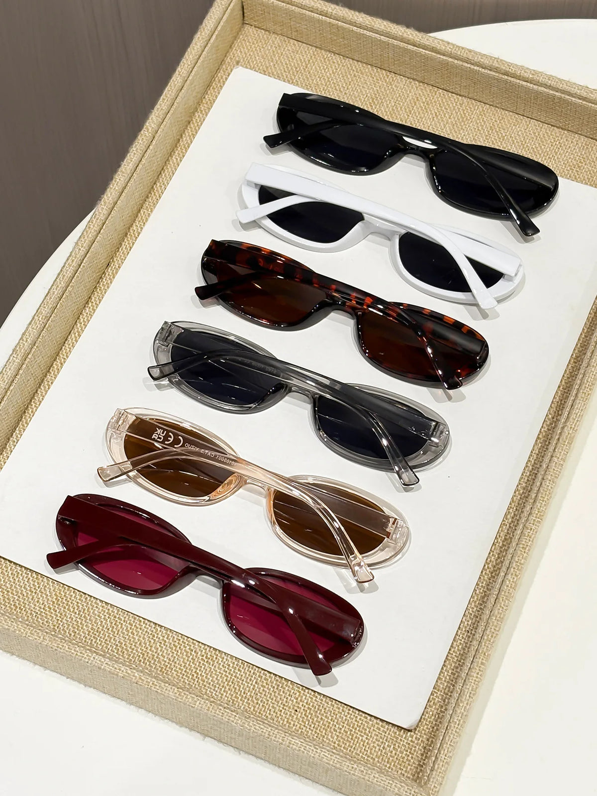 A collection of trendy leopard cat eye sunglasses in various colors and styles displayed in a light-colored box.