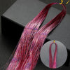 Long, vibrant pink and purple glitter hair extensions displayed on a black box.