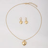 A delicate gold heart necklace and matching earring set displayed against a white background.