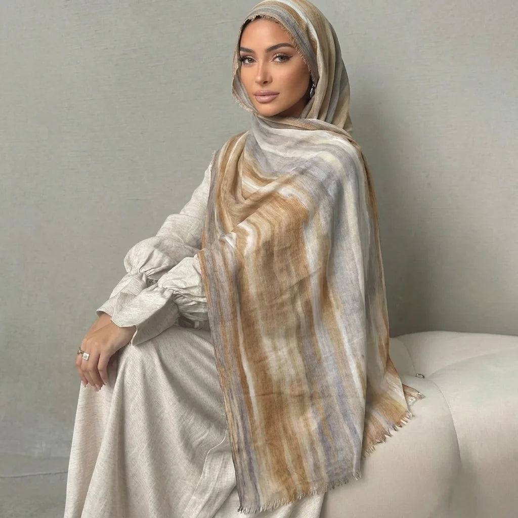 Una mujer vistiendo un elegante pañuelo de hijab a rayas beige y marrón y un atuendo a juego.