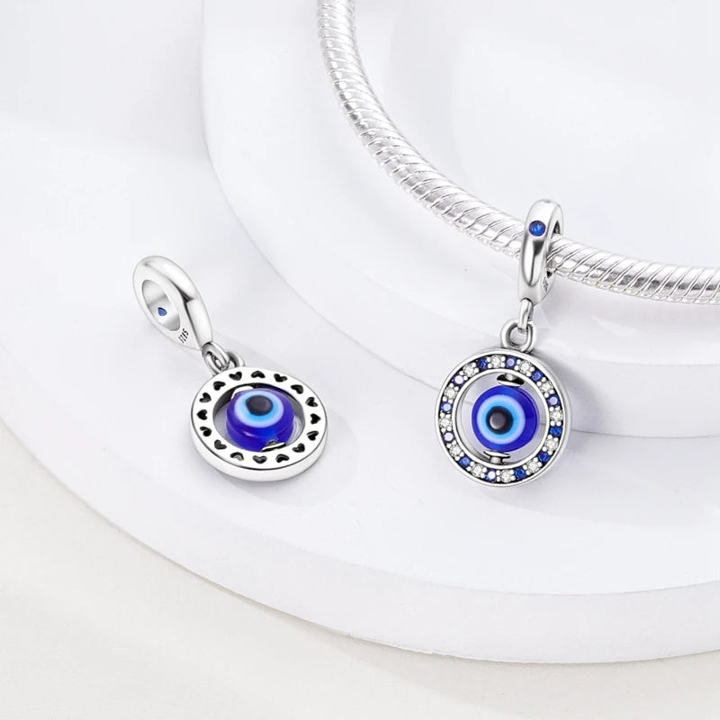 Sterling silver devil's eye charm bracelet featuring a round blue and black gemstone pendant.