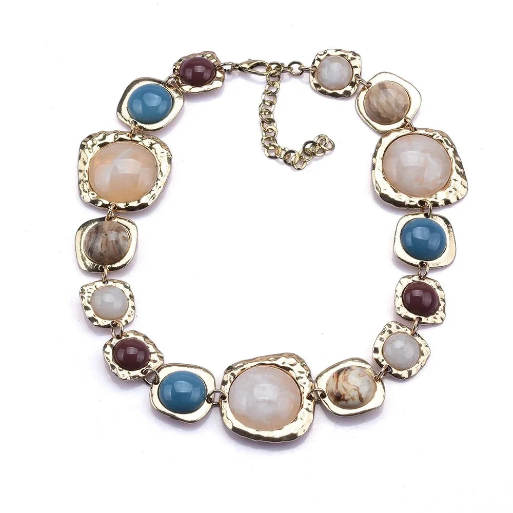 Boho gold plated resin statement choker necklace featuring round beads in shades of pink, blue, and beige.