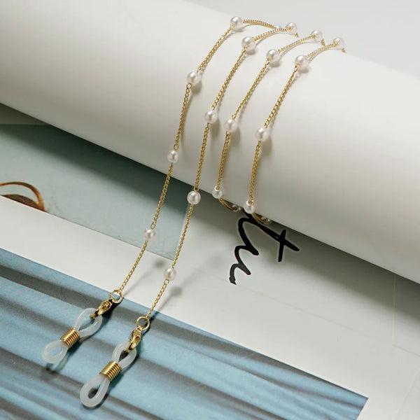Gold-toned pearl and bead eyeglass lanyards displayed on a light background.
