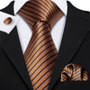 A close-up of a men's silk jacquard tie set featuring a gold and navy striped tie and a matching silk bow tie against a black