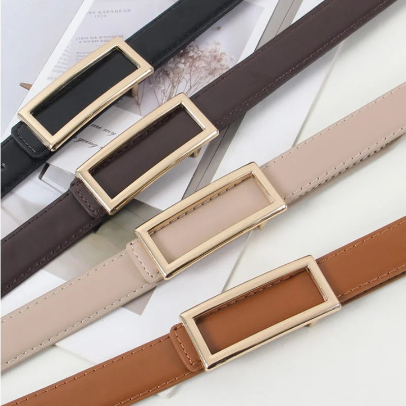 A close-up of a brown faux leather belt with gold-toned buckles and a light beige strap, shown against white paper.