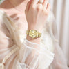 A close-up of a gold stainless steel quartz ladies wristwatch with luminous features worn on a wrist.