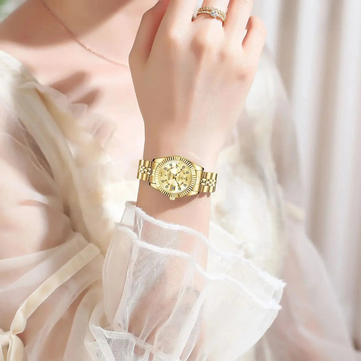 A close-up of a gold stainless steel quartz ladies wristwatch with luminous features worn on a wrist.