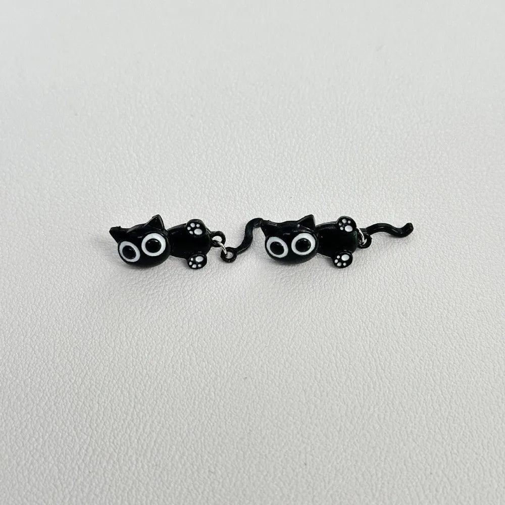 A pair of cute black cat stud earrings featuring small, stylized cats.