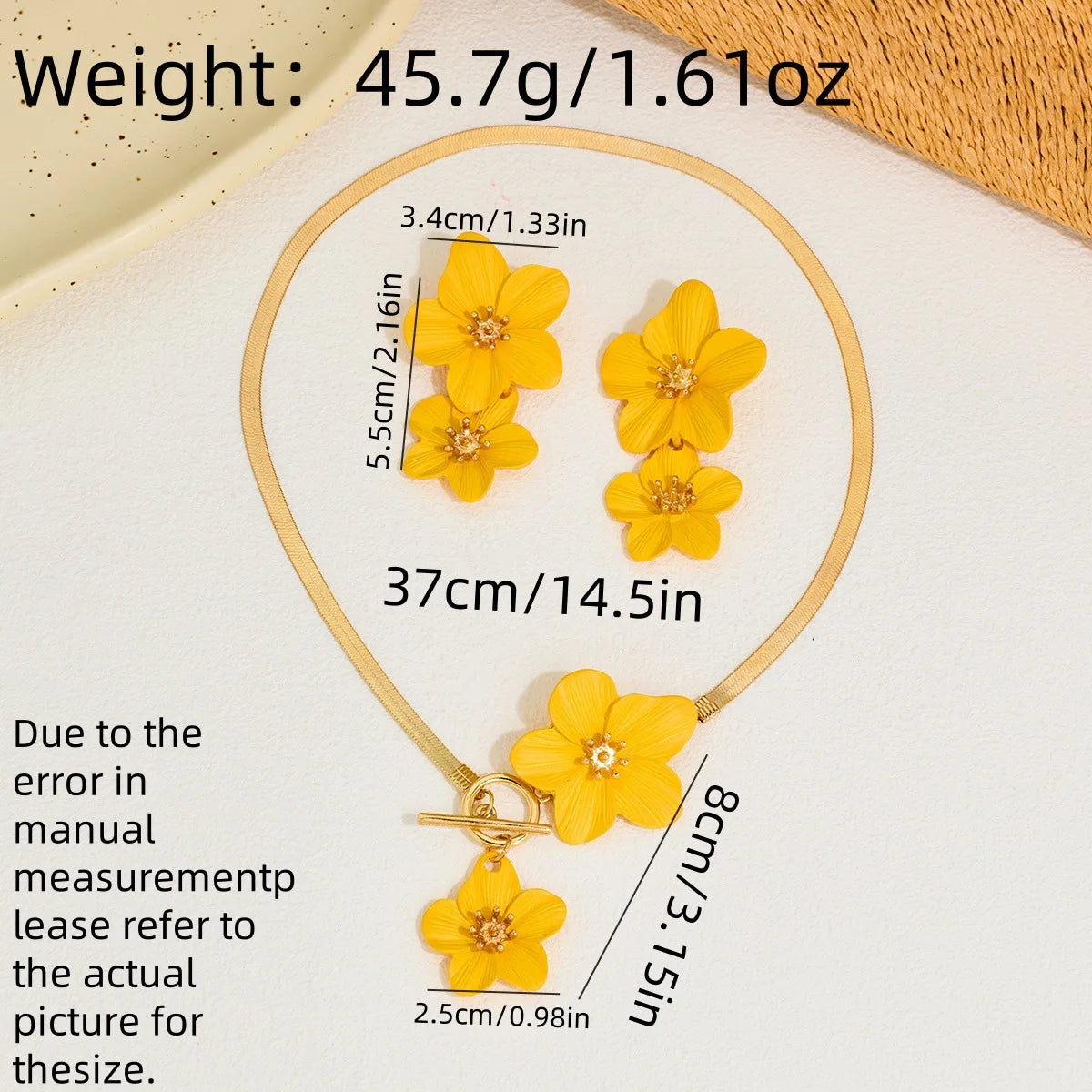 A gold-colored floral pendant necklace and earring set featuring yellow flowers on a white background.