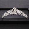A delicate silver-toned baroque crystal bridal crown displayed on a black velvet tray.