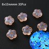 30 pieces of 8x12mm glow-in-the-dark acrylic beads scattered on a dark surface.