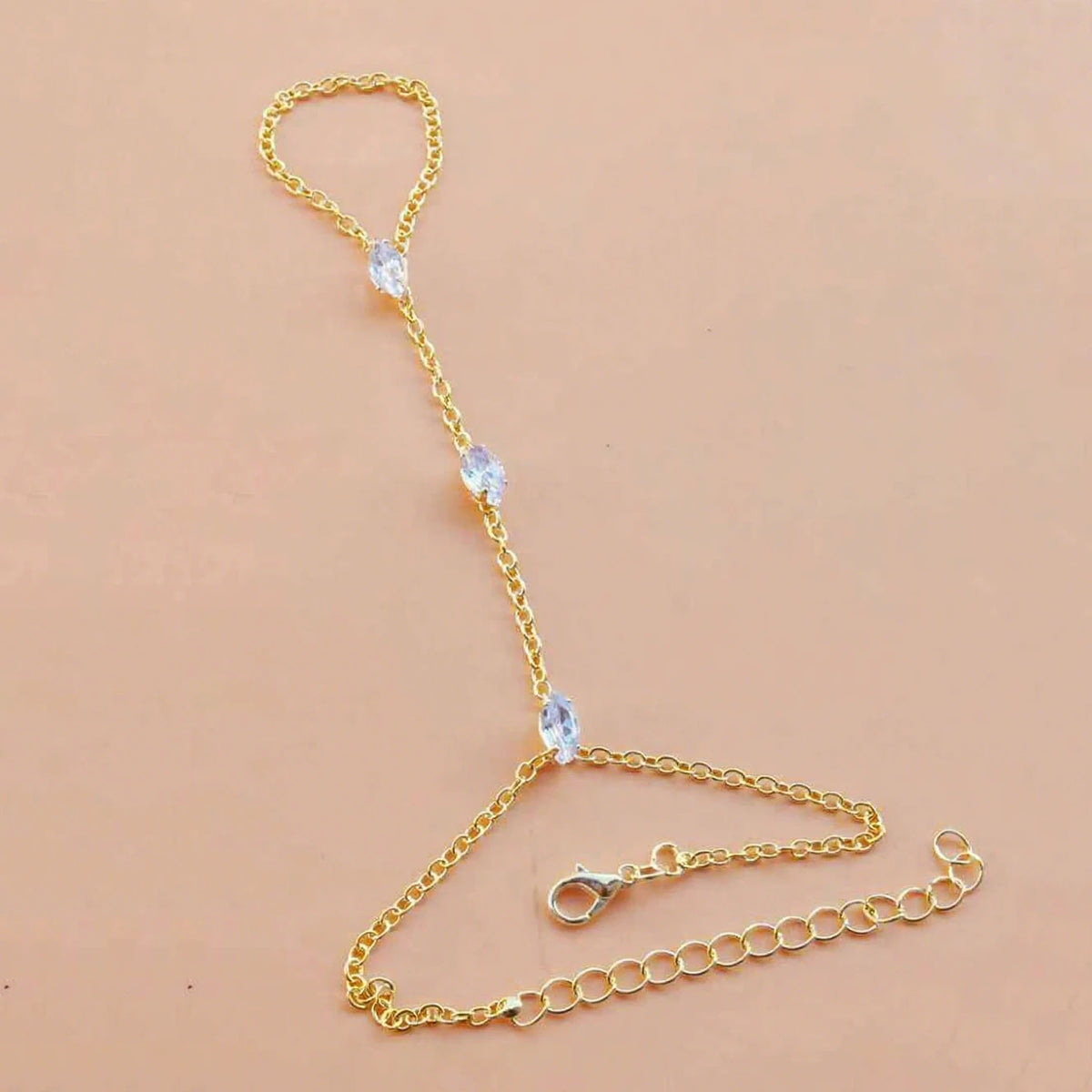 Gold-toned multilayer vintage ball link finger bracelets with clear stones displayed on a neutral background.