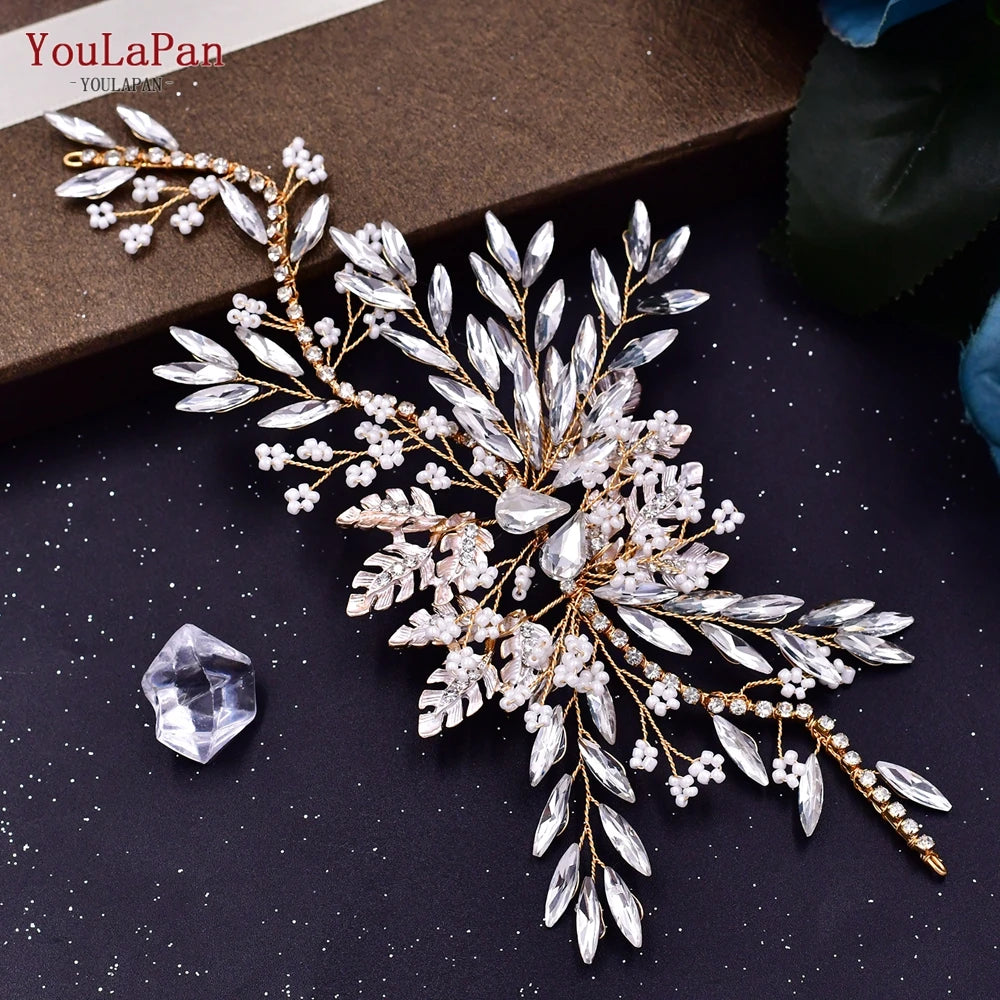 A delicate bridal headband or tiara made of clear crystals and gold-toned rhinestones with white floral accents.