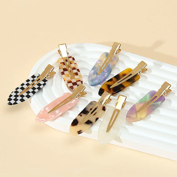 A set of gold-toned leopard print seamless hair clips featuring various animal prints and translucent colored resin.