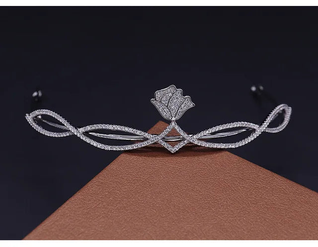Diadème de mariée en zircon cubique scintillant avec motif floral, présenté sur une surface marron.