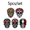 Five sets of colorful Mexican skull enamel pins featuring vibrant floral designs