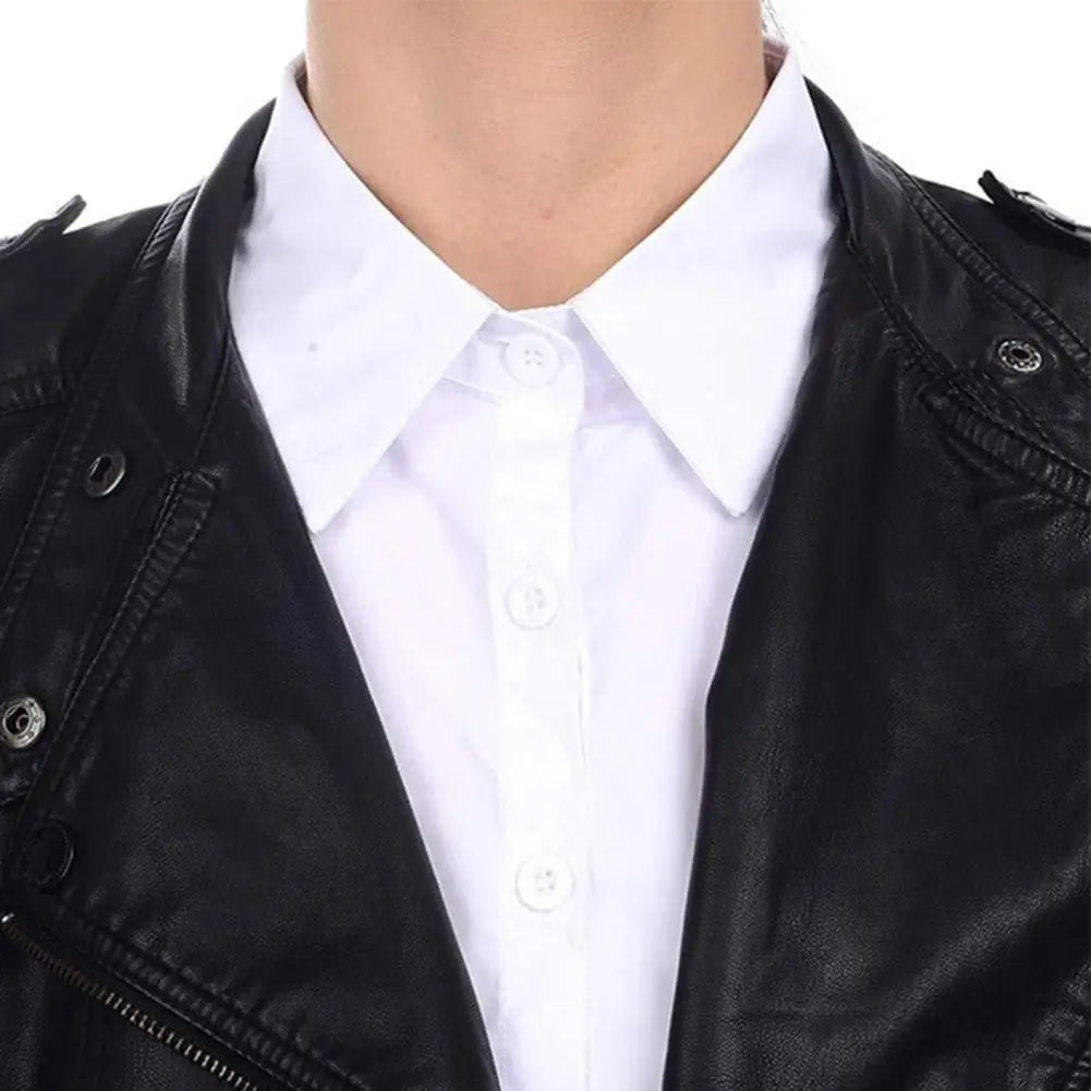 A close-up of a black leather jacket worn over a white collared shirt.