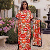 Eine Frau modelliert ein orangees Leopardenmuster-Satin-Abaya-Schal-Set vor einem weißen Gebäude.