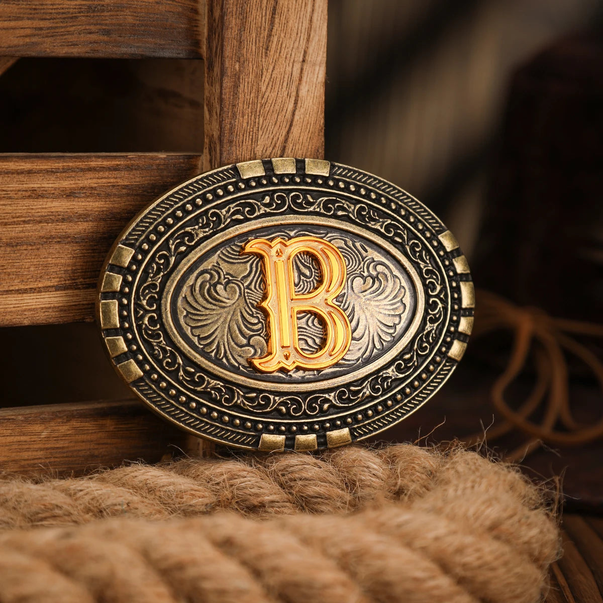 A vintage western belt buckle with a gold-toned design resting on a wooden surface.
