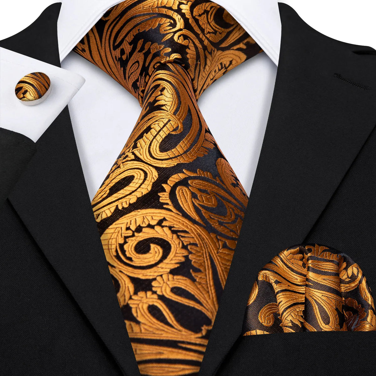 A close-up of a men's silk jacquard tie featuring an ornate gold and black pattern worn with a black suit jacket.