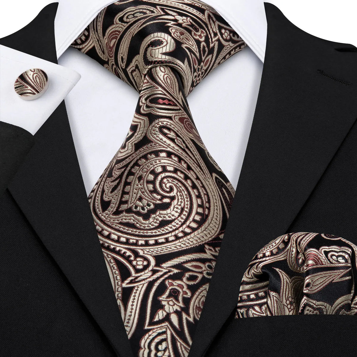 A close-up of a men's silk jacquard tie featuring an intricate paisley pattern worn with a black suit jacket.
