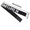 Black adjustable lace headband with white text that measures 60cm or 23.6 inches.