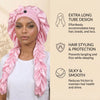 Una mujer vistiendo un gorro de satén rosa con largas cintas rizadas, estilizado para la protección del cabello.