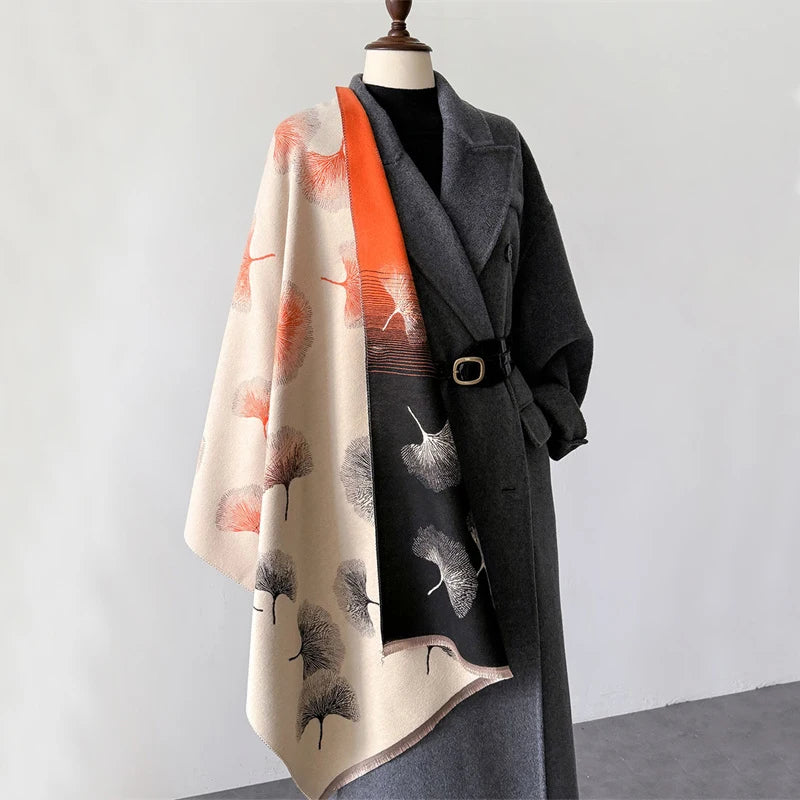 A gray coat features an orange and beige scarf wrap with textured detailing.